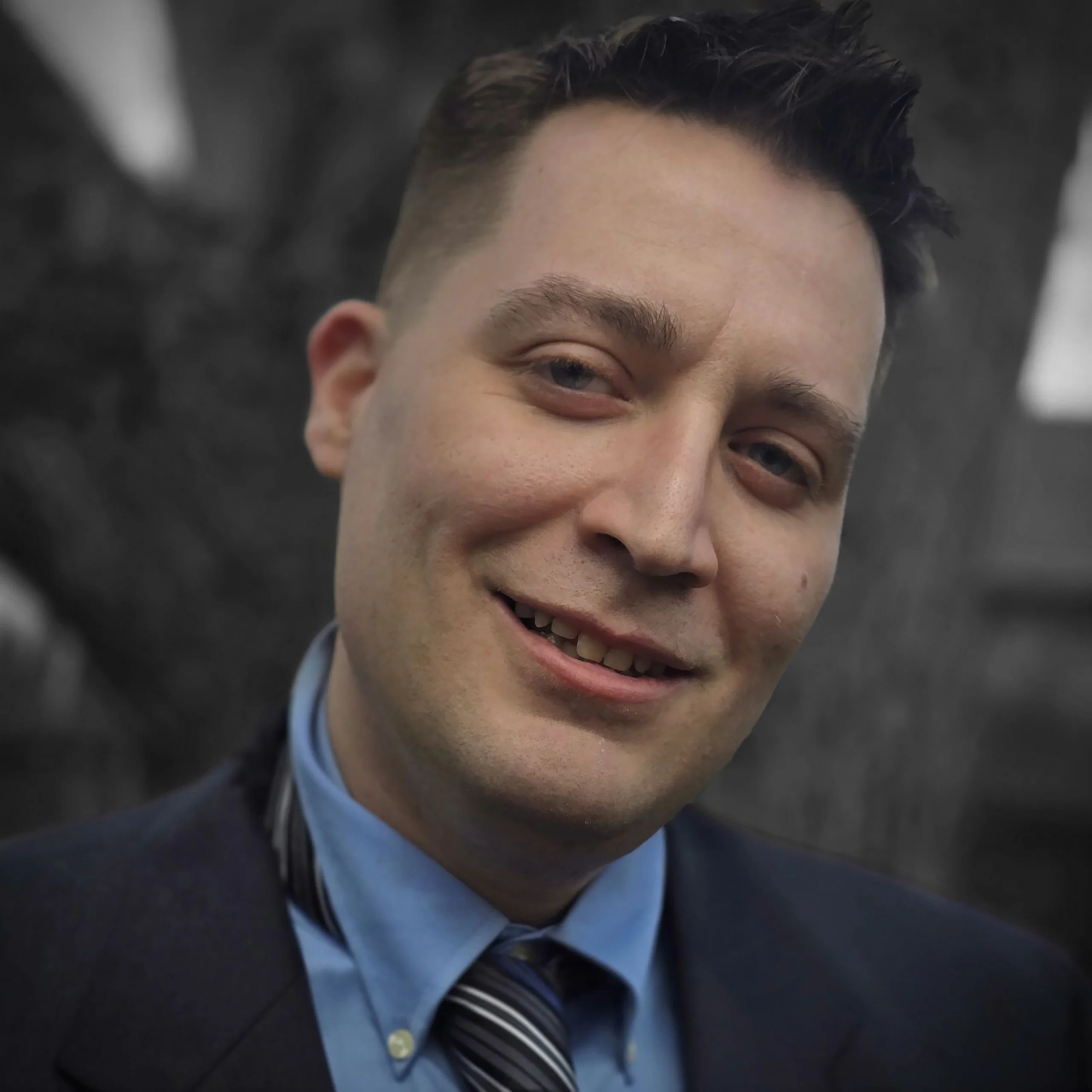 Picture of Owner Matthew standing in front of a tree in a suit